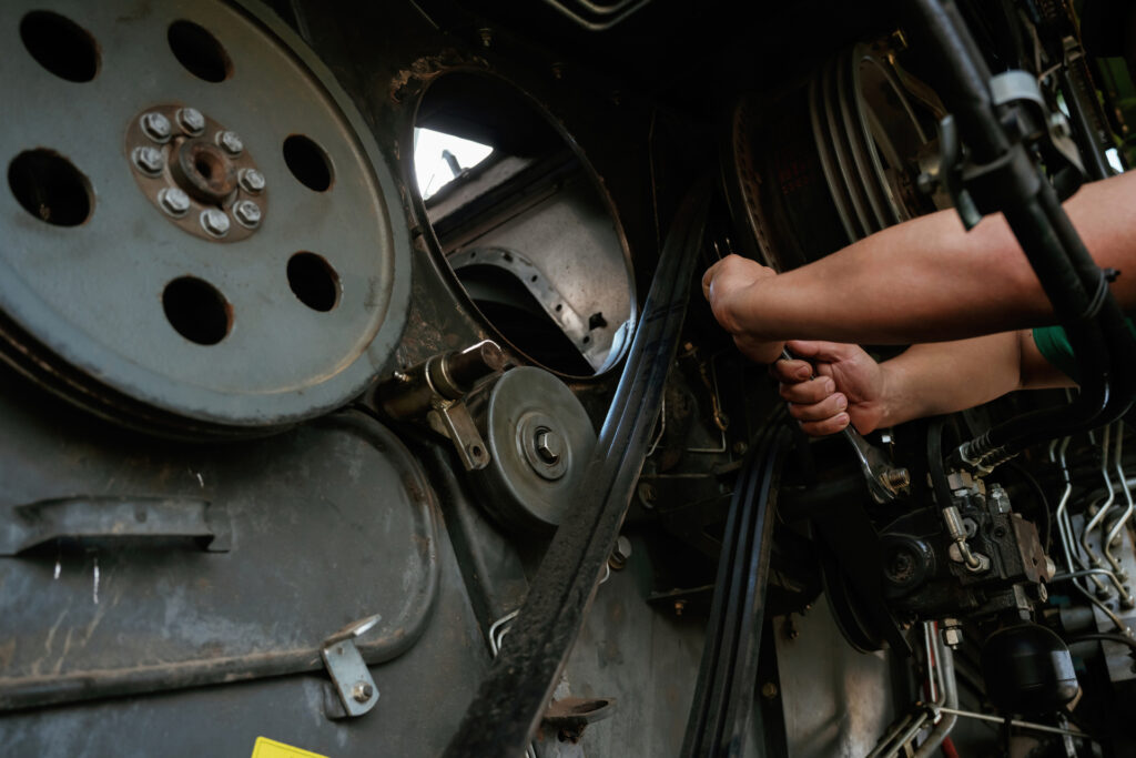 Mechanic working on industrial machinery in a workshop.