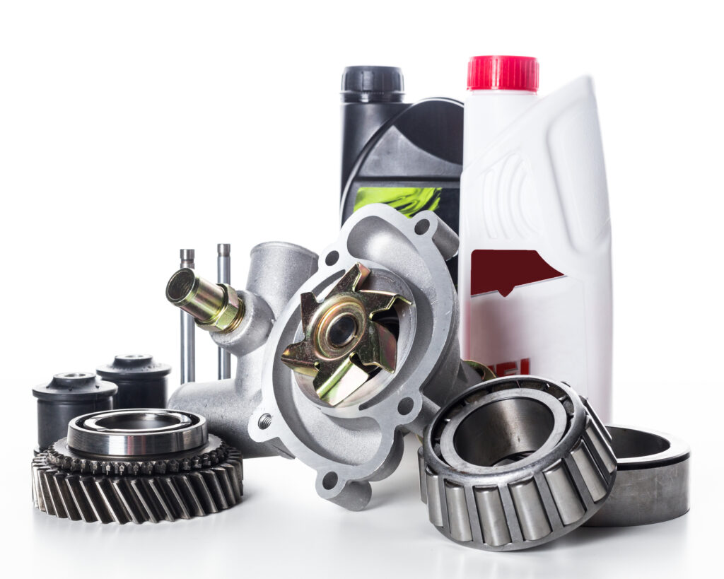 Various automotive components, including a water pump, gears, and engine oil containers, are neatly organized to support vehicle maintenance and repair activities in a workshop.