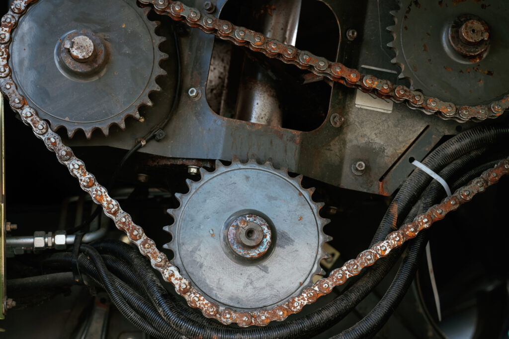Close-up of industrial gears and chains in machinery.